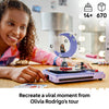 A girl smiling at the built LEGO Olivia Rodrigo's Concert Moon model, a 670-piece set for ages 14 and over
