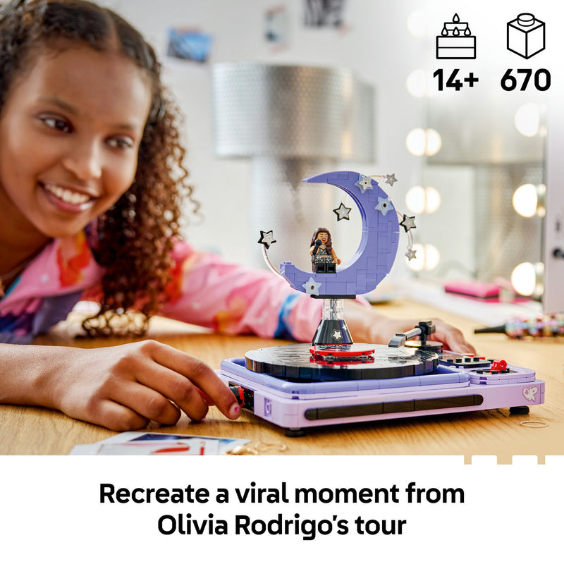 A girl smiling at the built LEGO Olivia Rodrigo's Concert Moon model, a 670-piece set for ages 14 and over
