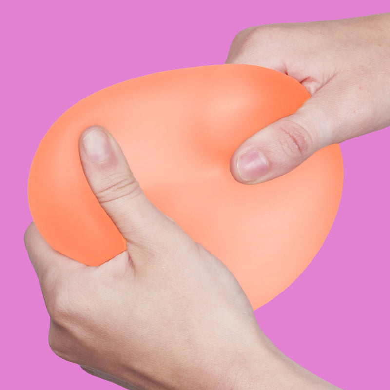 Hands squeezing the orange Speks Gump Jumbo Reef stress ball
