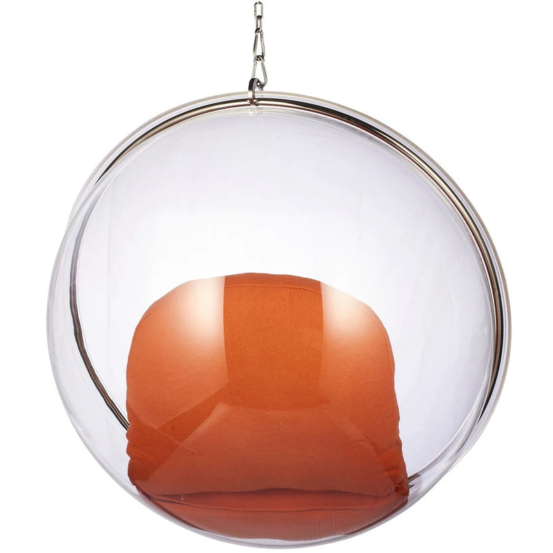 A modern hanging glass egg chair with a clear transparent spherical dome, a silver metal rim, and an orange upholstered seat, suspended by a chain against a white background.