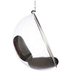 A modern clear acrylic hanging egg chair with a dark gray cushion inside, suspended by a silver metal frame and chain against a white background.