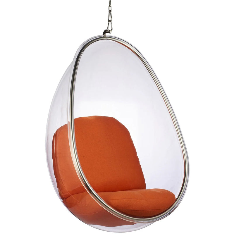 Clear hanging egg chair with orange cushioned seat and backrest, suspended by a metal chain with a chrome frame, on a white background.