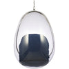 A modern egg-shaped hanging chair with a transparent clear acrylic shell, a dark navy blue fabric cushion inside, and a polished silver metal frame and hanging chain.
