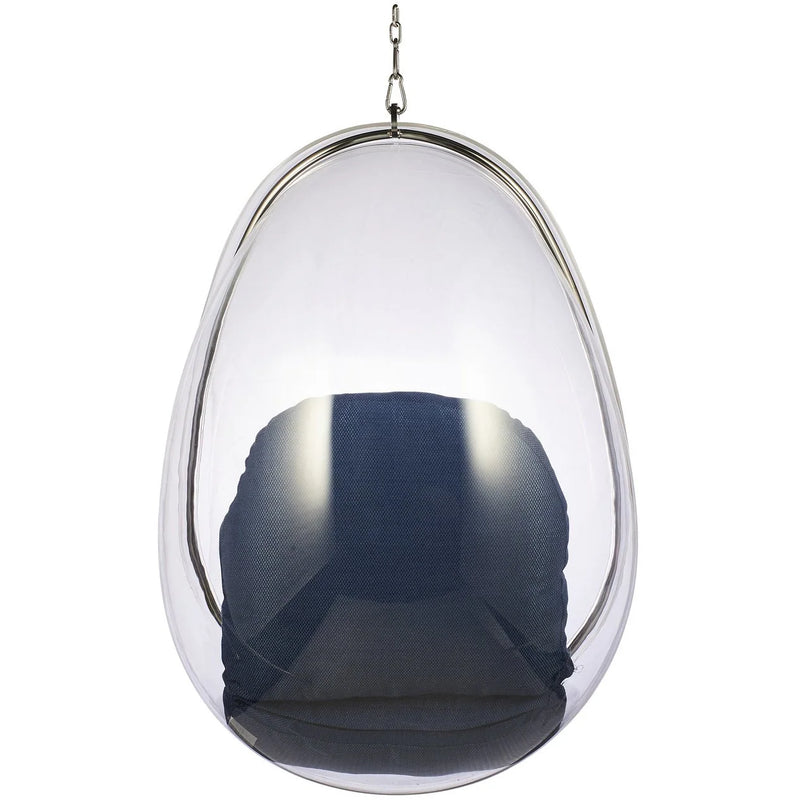 A modern egg-shaped hanging chair with a transparent clear acrylic shell, a dark navy blue fabric cushion inside, and a polished silver metal frame and hanging chain.