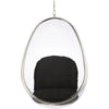 A modern egg-shaped hanging chair with a clear acrylic shell, a silver metal frame, and a black cushioned seat and backrest, suspended by a chain against a white background.