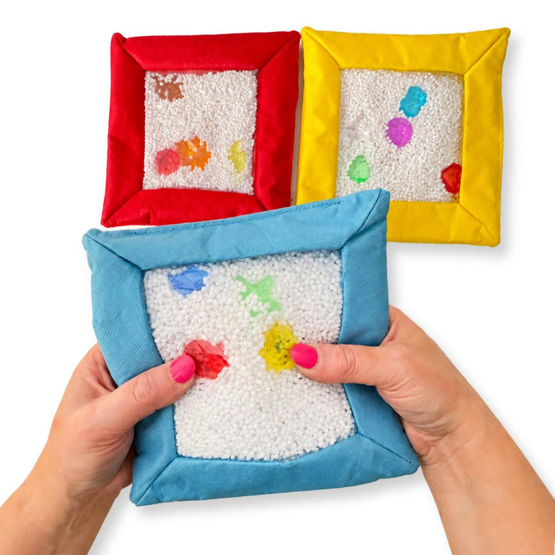 Hands pressing a blue Sensory Touch and Search Bag to move the filling and reveal shapes