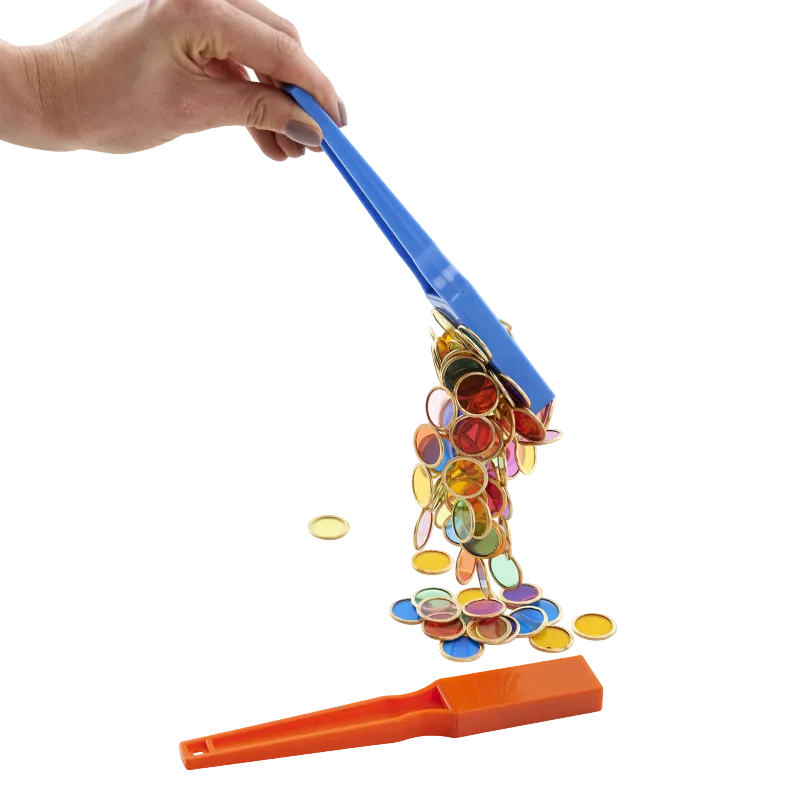 Colorful magnetic tiles being picked up by a blue and orange tool on a white background
