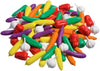 A pile of colorful plastic toy vegetables on a white background, including corn, carrots, peppers, garlic, and cucumbers in red, yellow, green, orange, purple, and white.