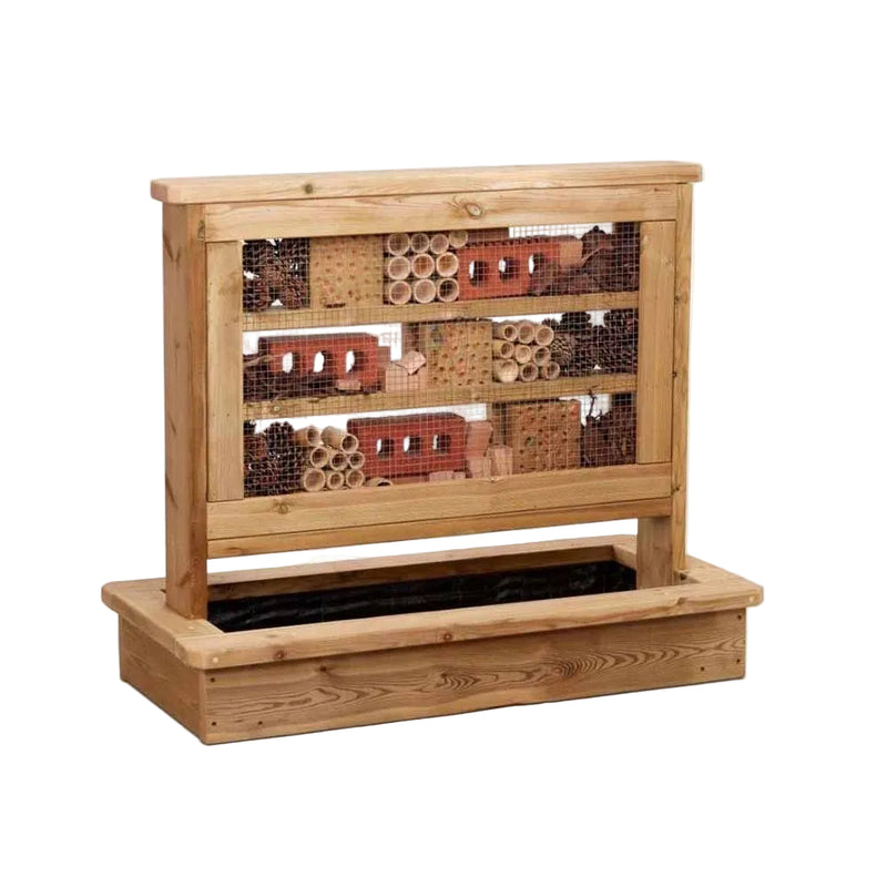 A wooden insect hotel with three tiers of nesting tubes and logs behind wire mesh, set in a matching wooden planter box on a white background.